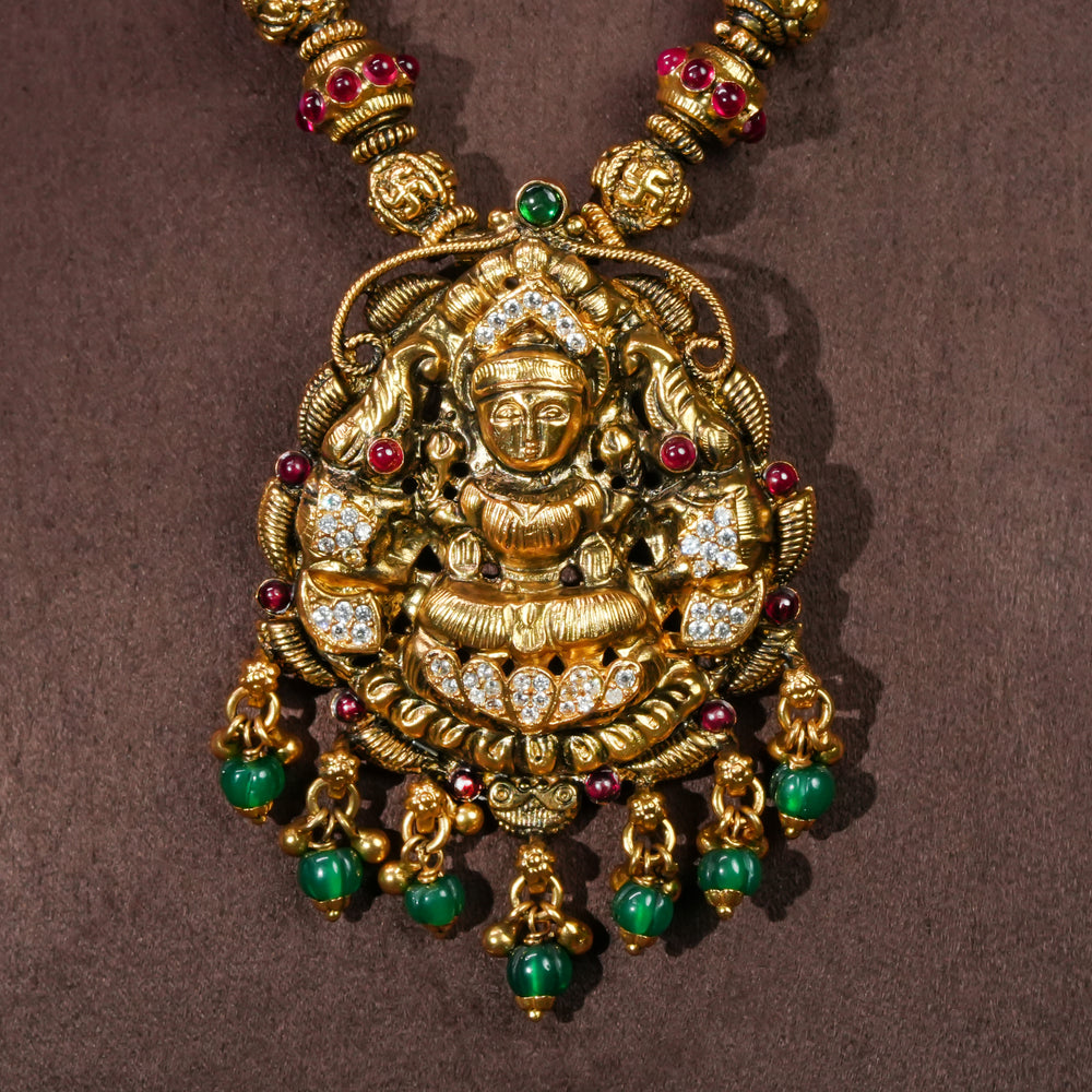 Close-up view of 92.5 sterling silver temple necklace with Lakshmi pendant, cz stone accents, antique gold finish, and traditional South Indian bridal jewellery design by Sri Fine Jewellery Hyderabad.
