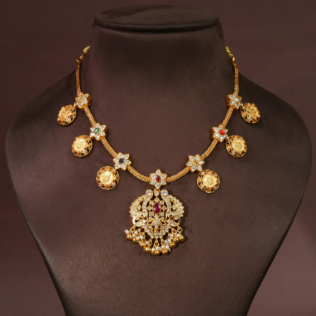 92.5 sterling silver floral necklace with antique coin motifs, ruby stone centerpiece, cz detailing, and traditional South Indian bridal pendant in premium gold finish by Sri Fine Jewellery Hyderabad.
