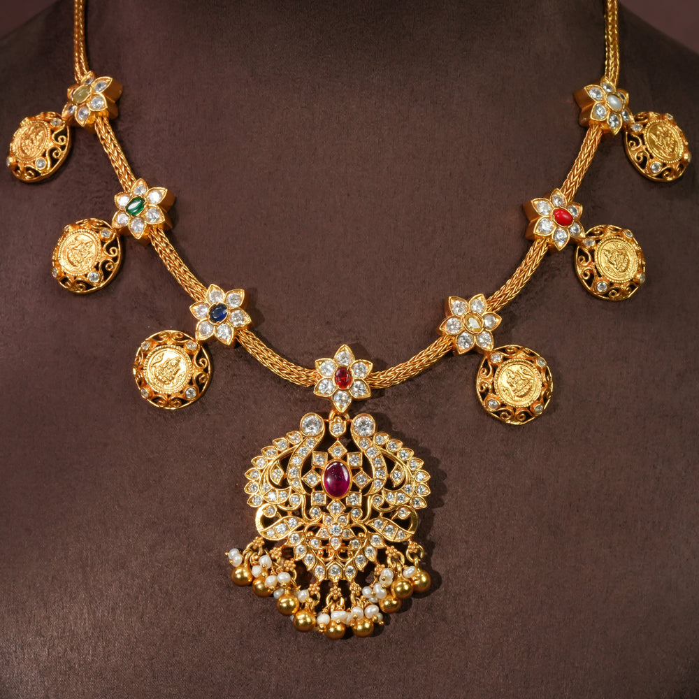 92.5 sterling silver floral necklace with antique coin motifs, ruby stone centerpiece, cz detailing, and traditional South Indian bridal pendant in premium gold finish by Sri Fine Jewellery Hyderabad.
