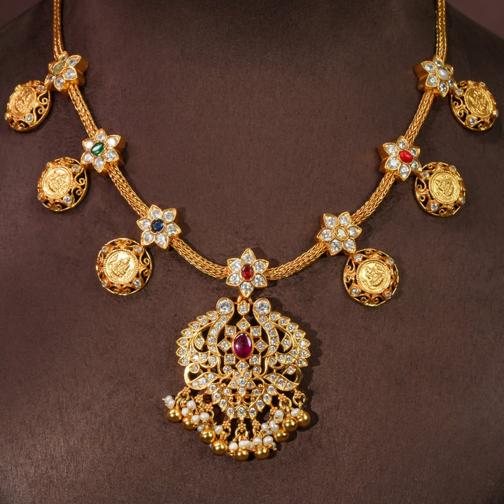 92.5 sterling silver floral necklace with antique coin motifs, ruby stone centerpiece, cz detailing, and traditional South Indian bridal pendant in premium gold finish by Sri Fine Jewellery Hyderabad.
