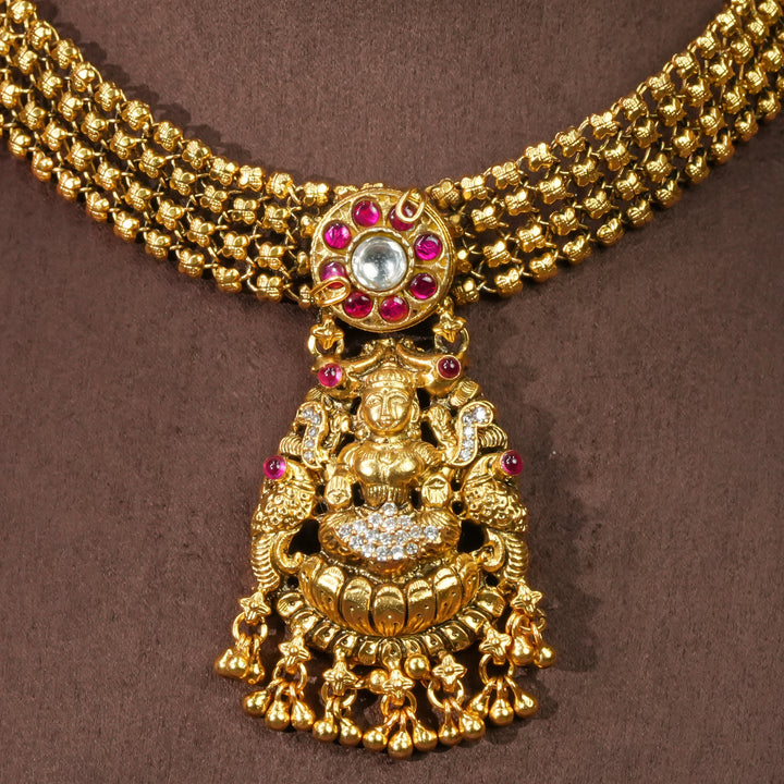 Close-up view of 92.5 sterling silver temple choker necklace with Lakshmi pendant, ruby stone accents, antique gold finish, and traditional South Indian bridal jewellery design by Sri Fine Jewellery Hyderabad.
(https://srifinejewellery.com)