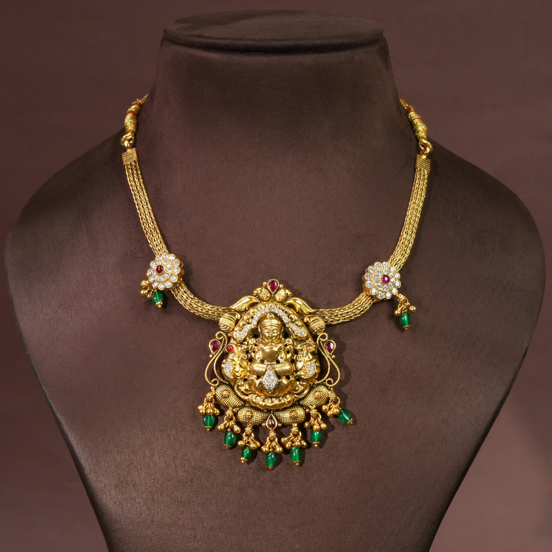 Traditional Lakshmi temple necklace in 92.5 silver with antique gold finish, cz stone detailing, green bead drops and handcrafted South Indian bridal jewellery design by Sri Fine Jewellery Hyderabad.
(https://srifinejewellery.com)
