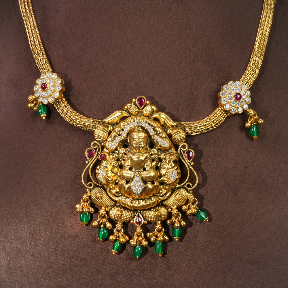 Traditional Lakshmi temple necklace in 92.5 silver with antique gold finish, cz stone detailing, green bead drops and handcrafted South Indian bridal jewellery design by Sri Fine Jewellery Hyderabad.
(https://srifinejewellery.com)