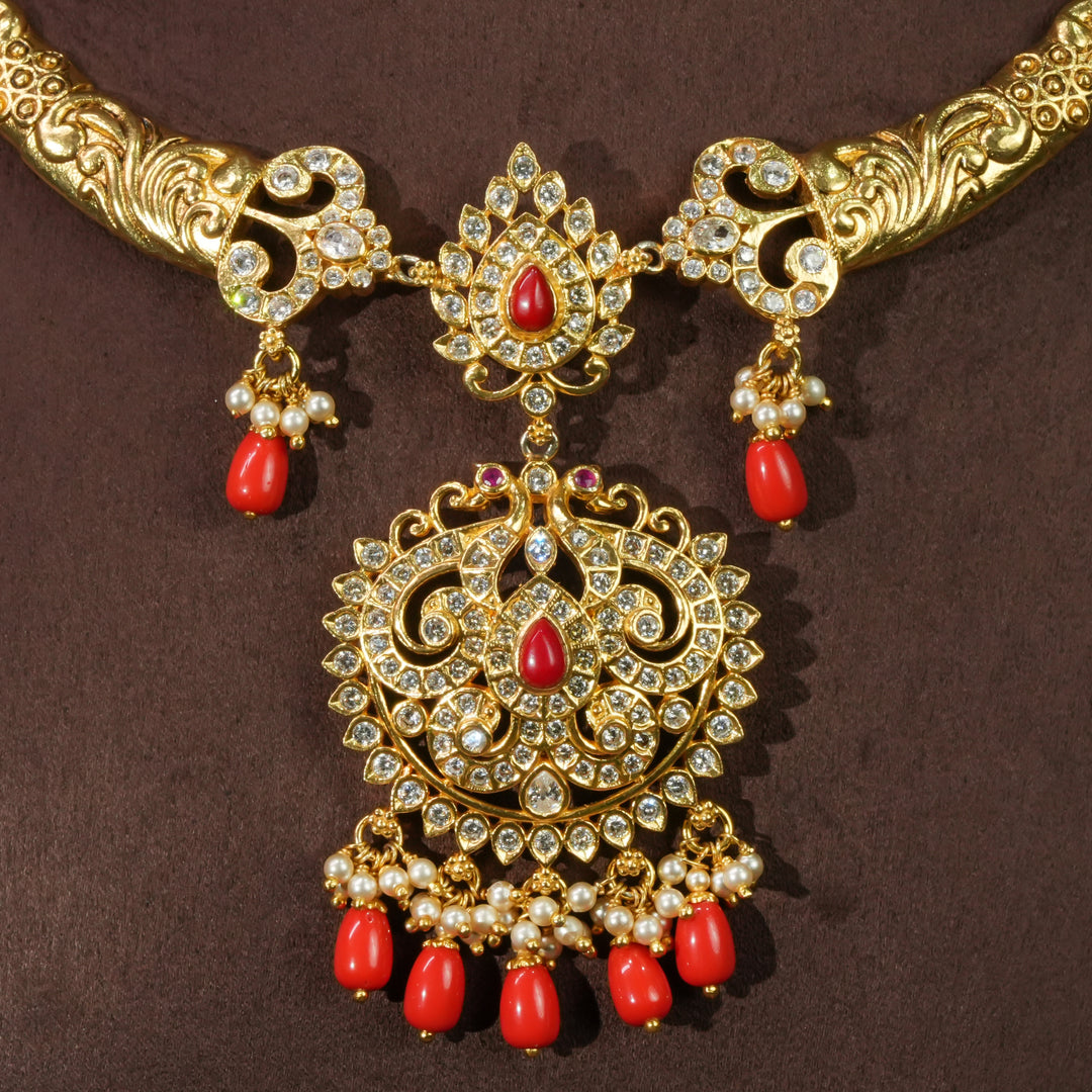 Close-up view of elegant traditional 92.5 sterling silver temple necklace with antique gold finish, cz stones, red bead drops and intricate handcrafted pendant design by Sri Fine Jewellery Hyderabad.
(https://srifinejewellery.com)