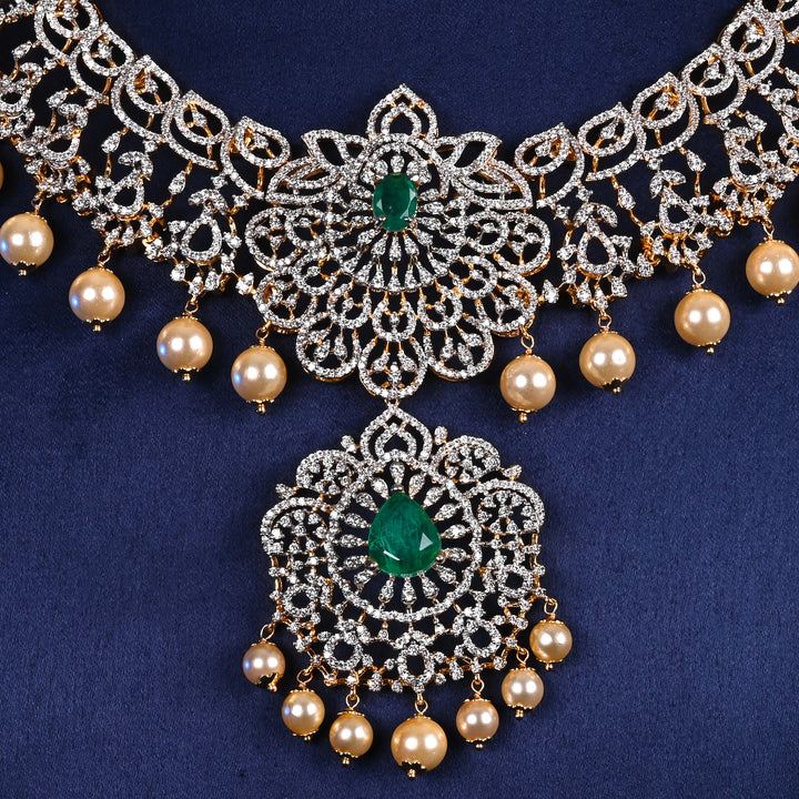 Close-up view of luxury diamond-look silver cz emerald necklace with premium cz stones, semi-precious emerald stone and  pearl drops in 92.5 silver, bridal wedding jewellery with gold finish by Sri Fine Jewellery Punjagutta Hyderabad.