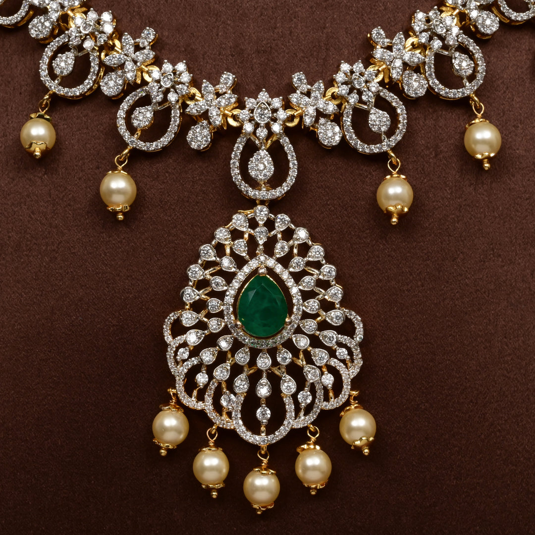 Close-up view of luxury diamond-look silver cz emerald necklace with premium cz stones, semi-precious emerald stone and  pearl drops in 92.5 silver, bridal wedding jewellery with gold finish by Sri Fine Jewellery Punjagutta Hyderabad.
