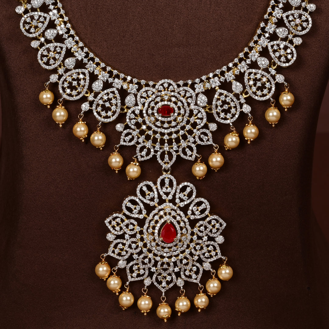 Close-up view luxury diamond-look silver cz ruby necklace with premium cz stones, semi-precious ruby stone and  pearl drops in 92.5 silver, bridal wedding jewellery with gold finish by Sri Fine Jewellery Punjagutta Hyderabad.