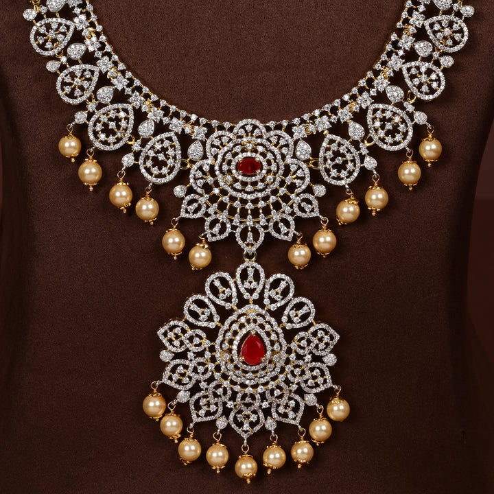 Close-up view luxury diamond-look silver cz ruby necklace with premium cz stones, semi-precious ruby stone and  pearl drops in 92.5 silver, bridal wedding jewellery with gold finish by Sri Fine Jewellery Punjagutta Hyderabad.